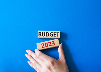 Budget 2023 symbol. Wooden blocks with words Budget 2023. Beautiful blue background. Businessman hand. Business and Budget 2023 concept. Copy space.
