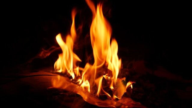 Fire burning vigorously, dark background yellow flame