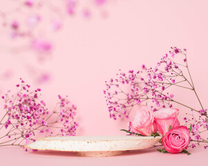 Wooden podium or product stage with pink roses on pink background.