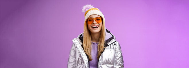 Stylish friendly charismatic blond woman in silver shiny jacket hat sunglasses ready learn...