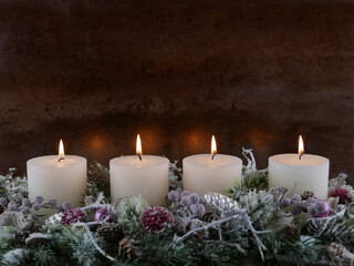 Schlichte Adventsdekoration zum vierten Advent. MIt weißen Kerzen Tannenzweigen und...