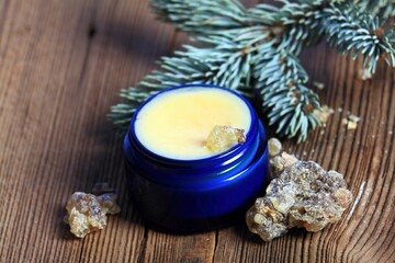 Fototapeta na wymiar Organic resin ointment, medicinal cream in blue glass. Cream from dried resin is good for joints and skin.