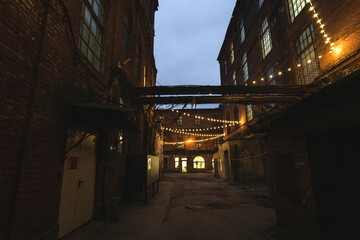 Dark street in an industrial area illuminated by small lanterns