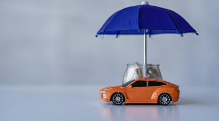 Businessman holding umbrella and close up toy car on table. Warranty. Repair. Finance. Banking and money concept.