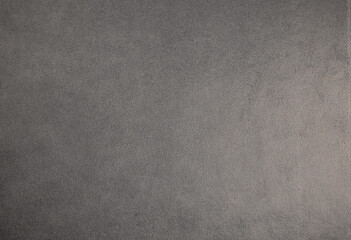 Fototapeta na wymiar Dark grey suede fabric background. Abstract texture wallpaper.