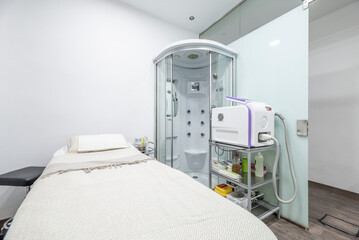 Massage cabin with table covered by towels with individual shower cabin with jets and beauty salon...