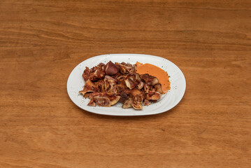 A typical tapa from Spanish bars with grilled ear with sauce for dipping