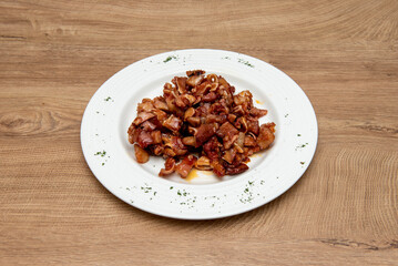 A typical tapa from Spanish bars with grilled ear with dipping sauce on a round plate with parsley around the edges