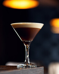 Coffee alcoholic cocktail. Alcoholic drink in cocktail glass on wooden table. Blurred background, soft focus. Copy space. - obrazy, fototapety, plakaty