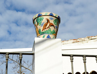 Maceta de cerámica decorada con motivos de montería en el poyete de la terraza de una casa de...