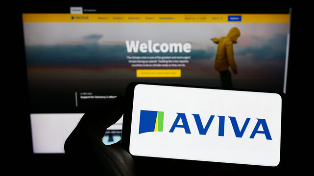 Stuttgart, Germany - 11-30-2022: Person holding cellphone with logo of British insurance company Aviva plc on screen in front of business webpage. Focus on phone display.