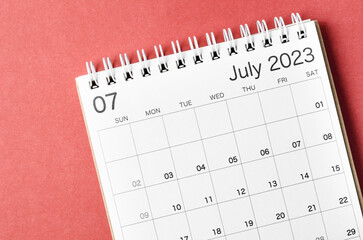 A July 2023 calendar desk for the organizer to plan and reminder isolated on red background.