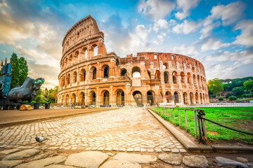 Fototapeta premium ruins of antique Colosseum building with grass lawn, Rome Italy