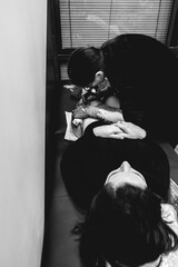 Young tattoo artist girl with glasses making a tattoo, with tattoo machine, of a big tiger, in the...