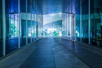 Empty asphalt road and glass wall architectural passageway