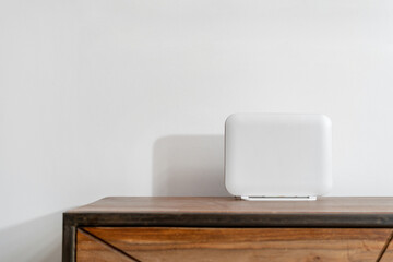 White wireless router stand on a wooden table in room
