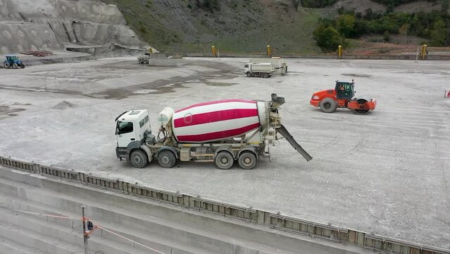 Aerial view of mixer truck in dam construction in mountains.