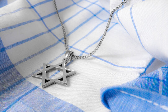Star of David Necklaces and Pendants, Magen David on white-blue fabric.