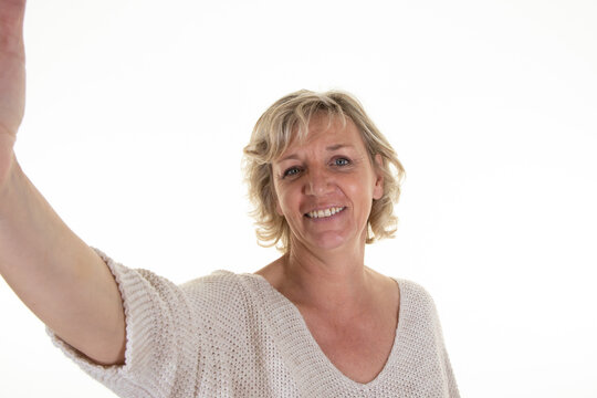 senior blonde woman on white background taking picture phone selfie with smartphone cell mobile