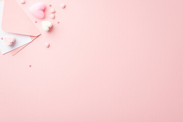 Obraz na płótnie Canvas Saint Valentine's Day concept. Top view photo of envelope with letter heart shaped marshmallow and sprinkles on isolated pastel pink background with copyspace