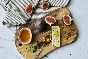 High angle view of stiil life of wooden tray with exotic fruits and cheese with honey