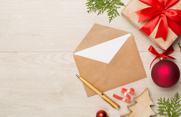 Craft envelope with christmas decoration on wooden background, top view