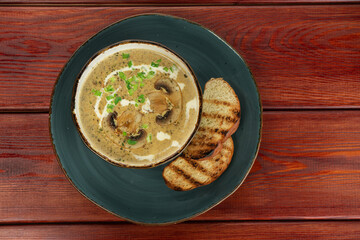 Mushroom Cream Soup in a bowl on a wooden background.