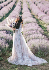 Beautiful bride in a lavender field at sunset. The concept of a wedding for two.