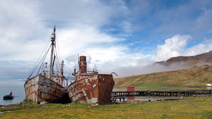 Old, rusted whaling and sealing ships beached in the harbor, at the old whaling station at Grytviken, South Georgia Island - obrazy, fototapety, plakaty