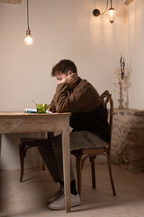 young boy reading book on paper, wooden table rustic design table decoration