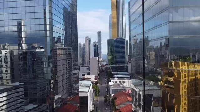 Flying inside cityscapes, near the high-rise building. apartment building from a height. glass buildings in Panama city.