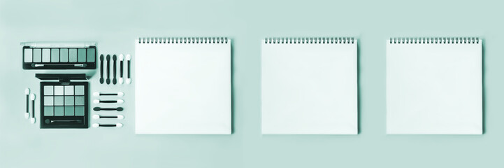 Pallet shadows and applicators with notepad on green background. Makeup eyes. Womens cosmetics. Beauty and eye image. Banner,