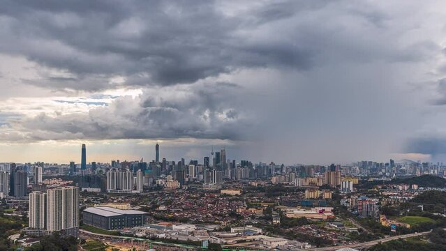 Monsoon cityscape time lapse with Dark clouds rain curtains and busy expressway against the Kuala Lumpur city skyline at sunset from afar in Malaysia. Zoom in motion timelapse. Prores 4KUHD.