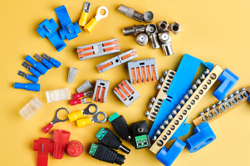 Different electrical tools isolated on yellow background, electrician equipment, wires, terminals, connectors, fuses, switches