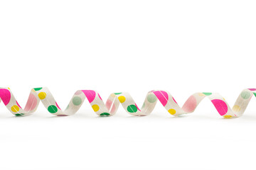 Guirnalda serpentina de papel con lunares de colores sobre un fondo blanco liso y aislado. Vista de frente y de cerca. Copy space.