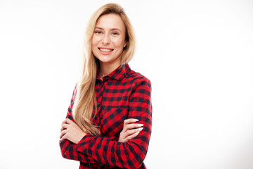 Portrait of attractive blonde girl in plaid red shirt posing and smiling joyfully isolated on white studio background