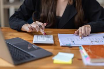 Portrait of business asian woman Accounting using calculating income-expenditure and analyzing real...