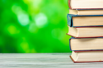 Composition with vintage old hardback books, diary, fanned pages on wooden deck table and red background. Books stacking. Back to school. Copy Space. Education background.	