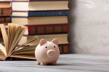Piggy bank stack of books. Saving for education. Copy space for text