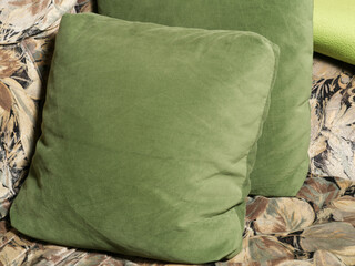 Two green pillows are lying on the sofa. Close