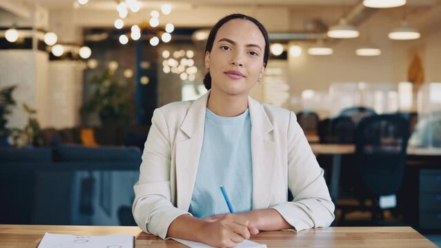 Lovely young brazilian or latino successful woman, business mentor, financial advisor, student, looking at webcam during consultation or webinar by video conference, takes notes in notebook, smiling