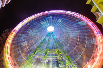 Vigo, Spain - December 05, 2022: Giant Ferris wheel in Christmas lights decoration, with tourists walking through its streets in the city of Vigo, Pontevedra, Spain