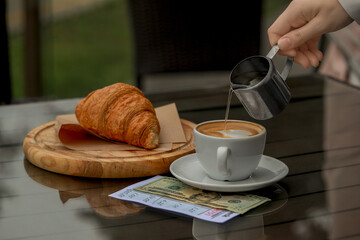 Waitress pouring coffee from pitcher into cup at table, closeup