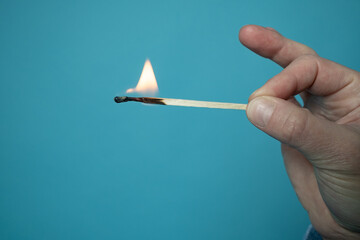 Burning match. Flame on the head and matchstick, on a blue background. 