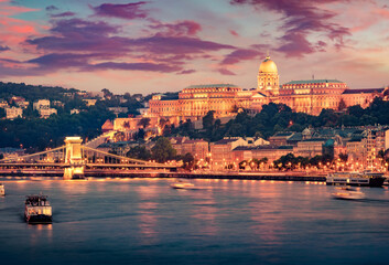 Fototapeta na wymiar Fantastic summer view of Buda Castle with city lights and ship on the Danube river. Picturesque sunset in Budapest, Hungary, Europe. Artistic style post processed photo.