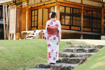日本庭園に立つ着物女子の後ろ姿