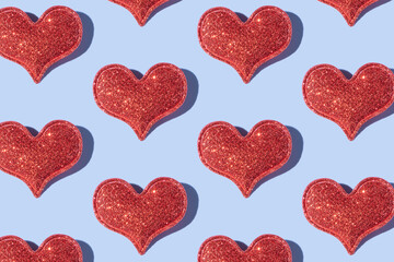 Pattern made from glitter heart shape on colored background with hard shadow. Valentines day minimalistic design