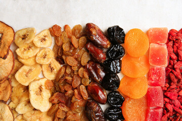 Different tasty dried fruits on paper, flat lay