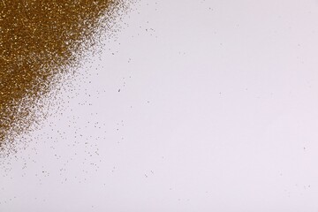 Shiny golden glitter on white background, top view