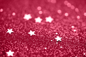 Beautiful Christmas viva magenta light background. Abstract glitter star bokeh and scattered sparkles